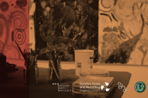Paintbrushes in glass jars sit on a table alongside a plastic container and packaged materials, with abstract artwork hanging on the wall behind them. Logos for the MSU Union Art Gallery and Surplus Store and Recycling appear overlaid at the bottom of the image.